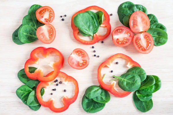 Trozos de verduras, tomates, pimientos, ensalada en un respaldo de madera —  Fotos de Stock