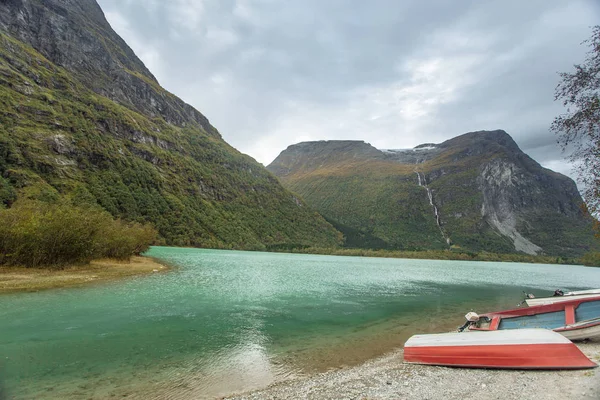 Barca rossa sulla riva con vista sulle montagne della Norvegia — Foto Stock