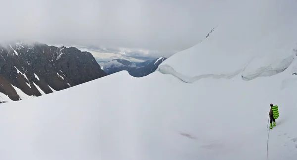 Альпинист в снежных горах — стоковое фото