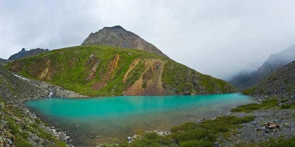 Beautifull turquoise lake with view to green hill — Stock Photo, Image