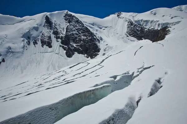 Fissures dans le glacier avec vue sur la neige haute montagne dans la journée ensoleillée — Photo