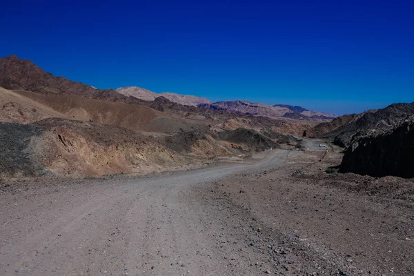 Chemin dans le désert dans l'Israil par temps ensoleillé avec des montagnes rouges et ciel bleu — Photo