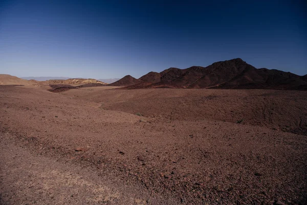 Chemin vers le canyon rouge dans l'Israil par une journée ensoleillée avec des montagnes rouges et un ciel bleu — Photo