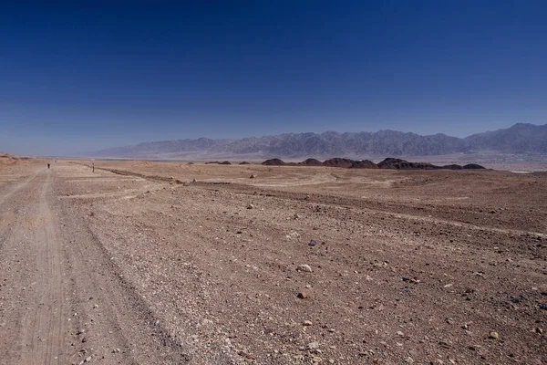 Chemin dans le désert dans l'Israil par temps ensoleillé avec des montagnes rouges et ciel bleu — Photo