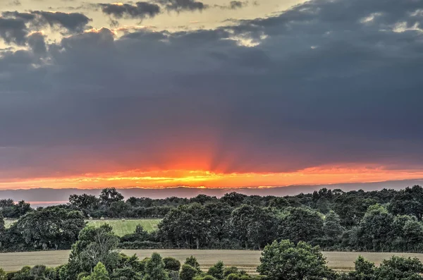 Die Sonne Geht Unter Einer Sanft Abfallenden Landschaft Mit Verstreuten — Stockfoto