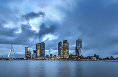 Dwan Erasmus Köprüsü ve Hollanda'nın Rotterdam, Kop van Zuid modern highrise üzerinde dramatik bir gökyüzüne