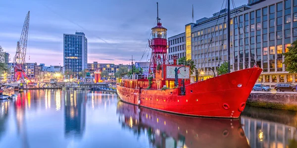 Rotterdam, Hollanda, 3 Mayıs 2017: Şimdi bir restoran bir eski kırmızı ışık gemiyle alacakaranlıkta Wijnhaven Limanı panoramik manzarasını