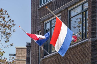 Rotterdam, Hollanda, 4 Mayıs 2020: İkinci Dünya Savaşı 'nın bitiminden 75 yıl sonra, Anma Günü' nde bir yerleşim yerinde iki bayrak direği yarıya indirildi.