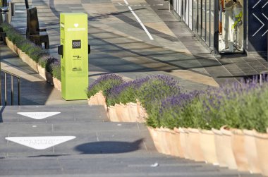 Rotterdam, Hollanda, 17 Mayıs 2020: Dezenfektan jel ve yayaları ayıran lavanta kapları ile Koopgoot alışveriş caddesine çıkan merdiven