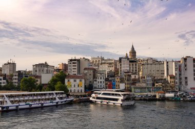 Türkiye İstanbul, Temmuz 2019. Karaköy rıhtımındaki Galata köprüsünden feribot ve arka planda Galata Kulesi manzarası