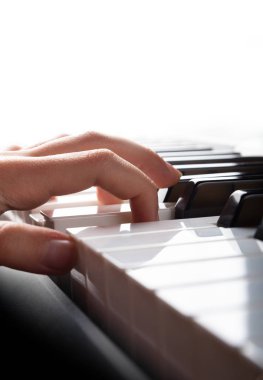 Elektronik sentezleyici piyano tuşlarıyla oynayan çocuk elleri yakından görülüyor. Müzik dükkanları, posterler, reklam broşürleri, kartvizitler, web sunumları için dikey fotoğraf hazır. Metin için yer