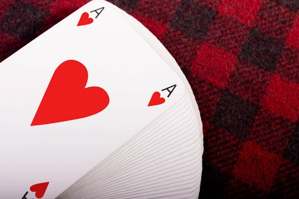 Kareli ekose üzerinde kupa ası olan bir deste iskambil kağıdı. Yatay fotoğraf. Metin için yer