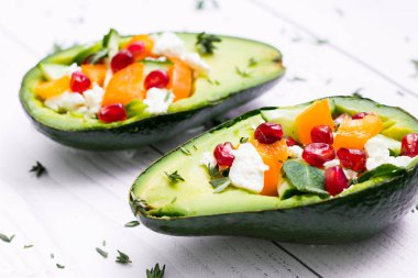 salata avokado, taze sebze, beyaz peynir, Garnet ve mandalina. sağlıklı beslenme veya vejetaryen yemek beyaz bir arka plan üzerinde