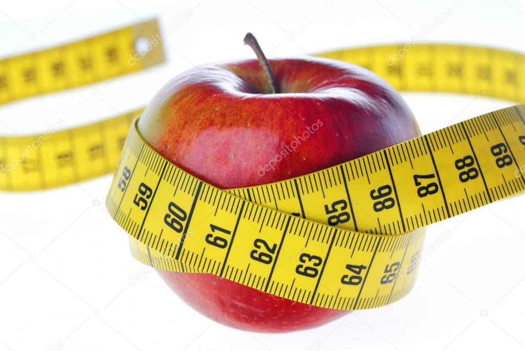 raw ripe apple with measuring tape isolated on white background, close-up 