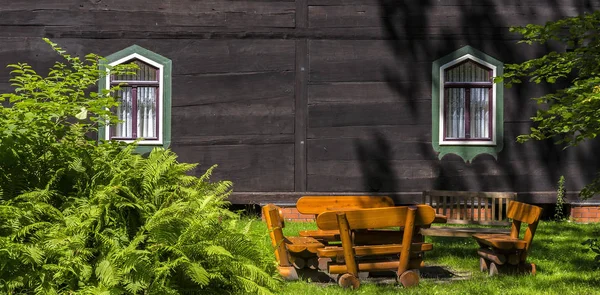 Fotografia Zielony Paproci Pozostawia Pobliżu Drewniany Dom — Zdjęcie stockowe