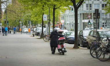 Pembe Scooter yaşlı kadınla Caddesi üzerinde