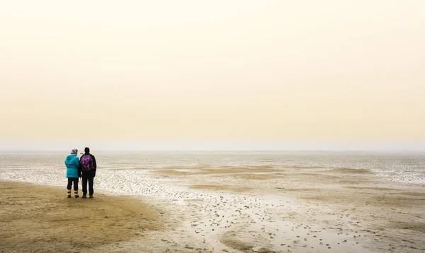人们在海边漫步在雾中 — 图库照片