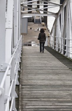 Metal köprüden yürüyen kadın. Arka 