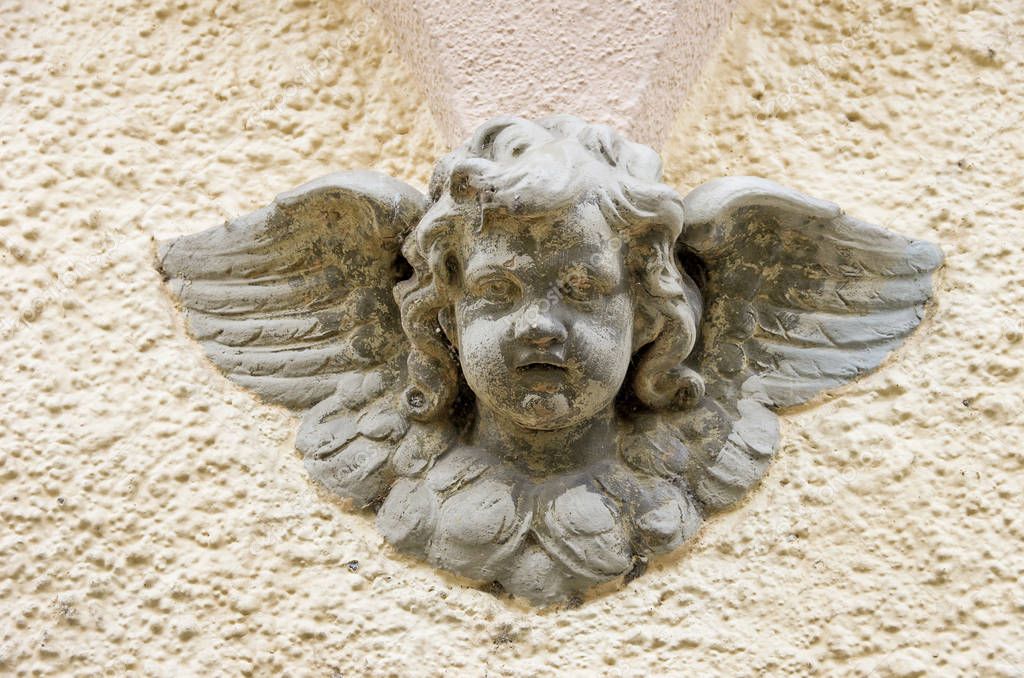 Face And Wings Of Some Infant Angel At The Facade Of An Old Residential Building, Lindau In Lake Constance, Germany