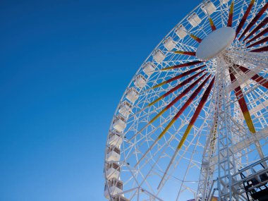 Bir fuarda mavi gökyüzü karşı dönme dolap 