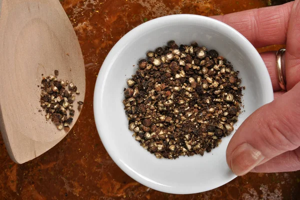 Vrouwelijke Hand Bedrijf Kom Met Biologische Zwarte Peper — Stockfoto