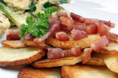 kızarmış patates kızarmış domuz pastırması dilimleri ve omlet beyaz tabakta ile yakın çekim  