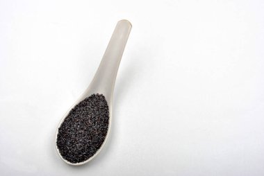 Beyaz arka plan üzerinde izole kaşık üzerinde organik haşhaş tohumu 