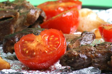 Kızarmış domates soğan ve et parçaları ızgarada