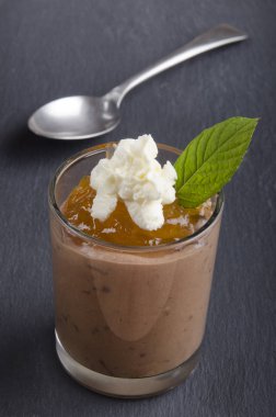 çikolata mascarpone tatlı turuncu mousse ve kayrak üzerine bir bardak krem şanti ile