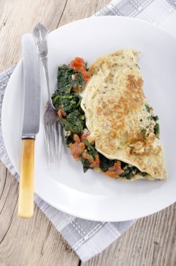 omlet ıspanak ve plaka üzerinde domates ile yakın çekim  