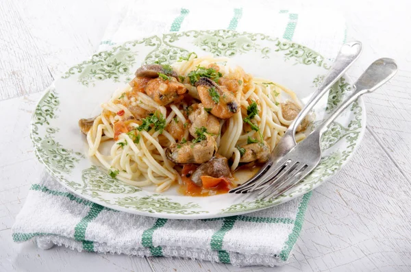italian dish with spaghetti and mussels with chili and parsley