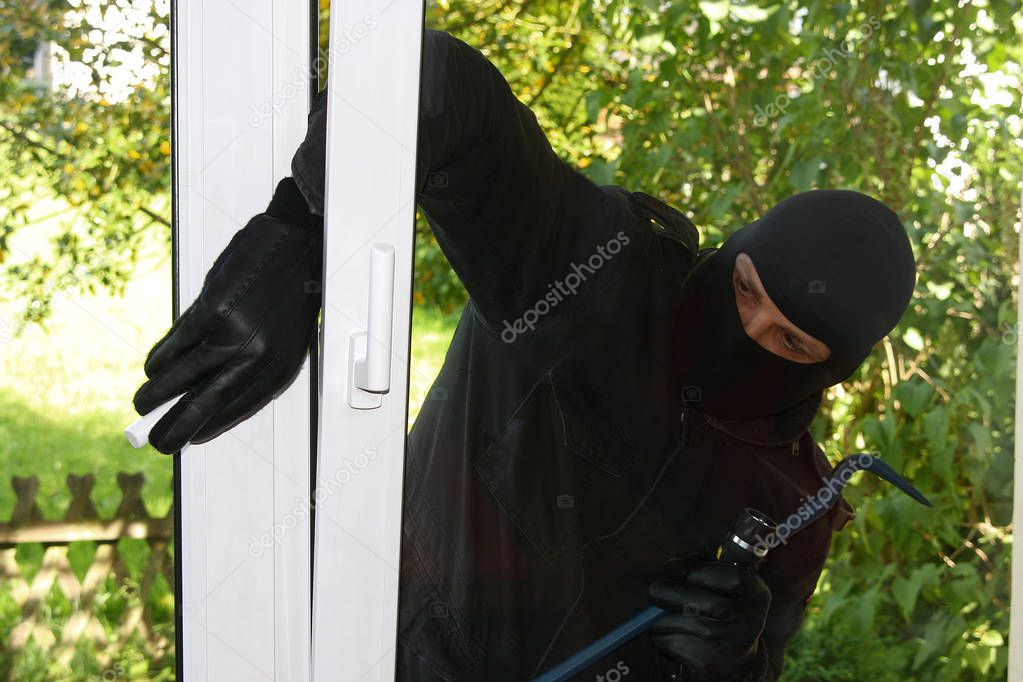 criminal Burglar in black clothes in balaclava on head
