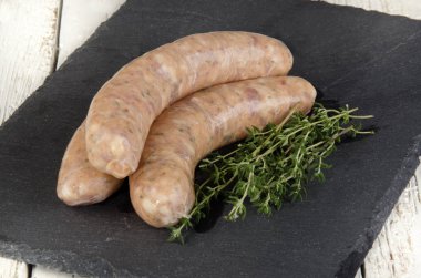 Kayrak bir plaka üzerinde kekik ile doğal çerçeve içinde otlar ile sosis ızgara