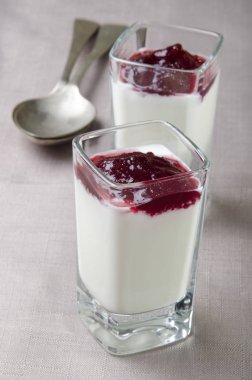 taze ev yapımı çilek Mus fondip bardakları ve kahverengi masa örtüsü üzerinde kaşık yoğurtla 