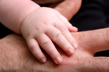 Bebek el tutarak üst el, yakın çekim, aile kavramı  