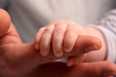 Bebek el tutarak üst el, yakın çekim, aile kavramı  