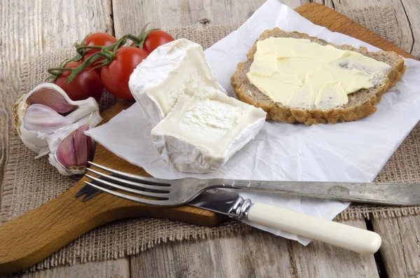ヤギのチーズ フォークとナイフで木の板 — ストック写真