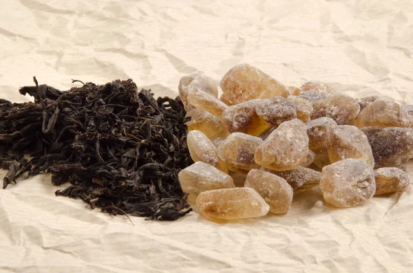Brown Rock Candy Sugar And Black Tea On Brown Paper