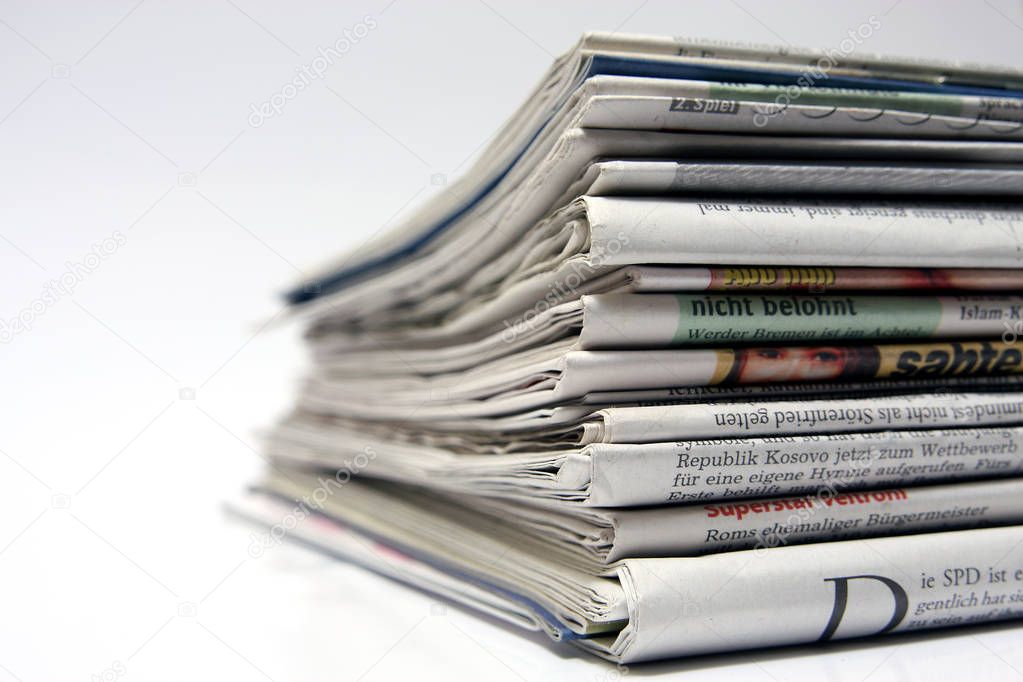 pile of newspapers isolated on white background, close-up 
