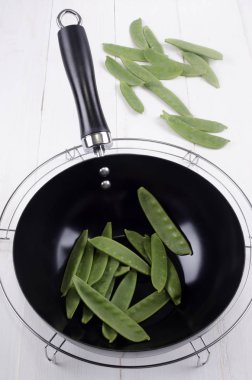 Çiğ sebze içinde A siyah Wok üzerinde soğutma raf