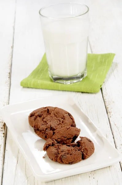 stock image Chocolate Biscuit On White Plate And A Glass Of Cold Milk In The Background