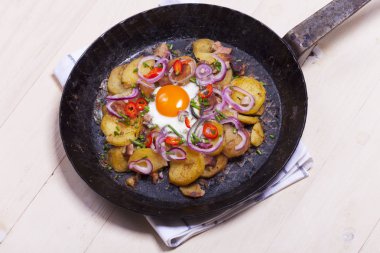 Pastırma ve maydanoz bir dökme demir tavada ile organik patates kızartması