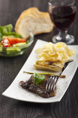 ızgara biftek fesleğen ve çatal beyaz tabakta yakın çekim 