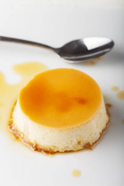 Beyaz arka plan üzerinde izole kaşık ile tatlı puding yakın çekim 