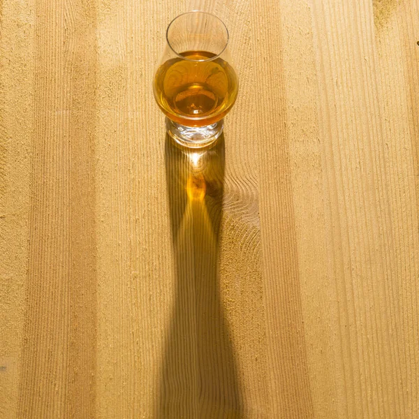 木製のテーブルに太陽の影とウイスキーのガラス — ストック写真
