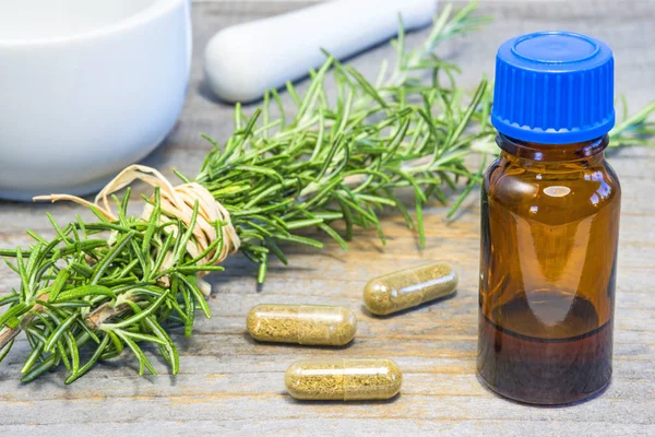 yakın çekim yeşil taze biberiye bitki ile kahverengi cam şişe