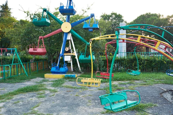 Carrossel abandonado velho e atrações no parque da cidade — Fotografia de Stock