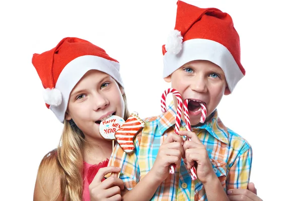 Children in red caps with Christmas sweets isolated — Stock Photo, Image