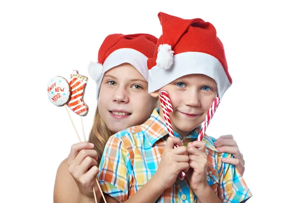 Dzieci w czerwone czapki z Boże Narodzenie słodycze na białym tle — Zdjęcie stockowe