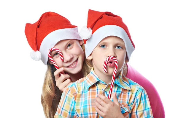 Děti v červené čepice s vánoční cukroví, samostatný — Stock fotografie